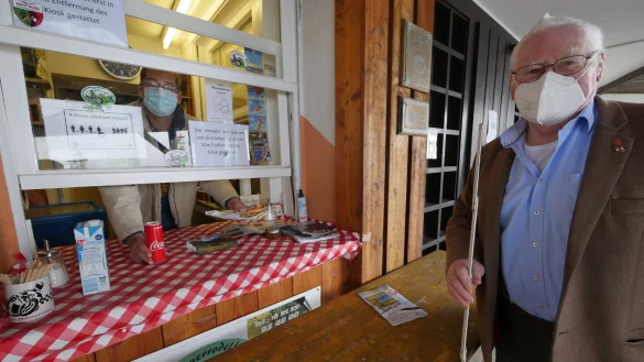 K&ouml;terberg-Wirt Florian Brand reicht am Kiosk eine Cola und eine Bockwurst durchs Fenster. Dass heute wenig G&auml;ste da sind, liegt an Sturmtief Eugen, das um die Ecken des K&ouml;terberghauses pfeift und nicht am Coronavirus. Seniorchef Rudolf Brand steht trotzdem mit dem Zollstock parat, um die Einhaltung der Mindestabst&auml;nde der G&auml;ste zu &uuml;berpr&uuml;fen. - &copy; Jost Wolf