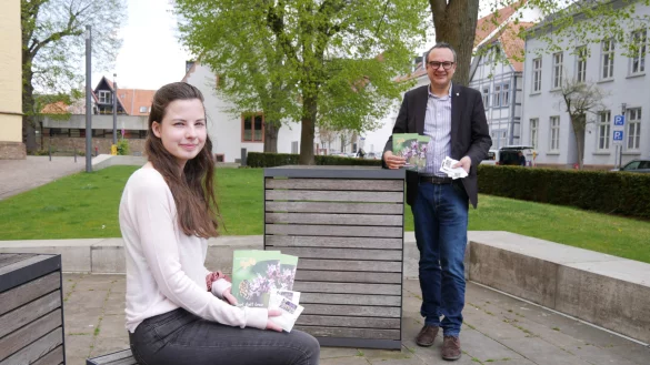 Auszubildende Talea Benner und B&uuml;rgermeister Markus Baier pr&auml;sentieren die Brosch&uuml;re &bdquo;Bunt statt Grau" und die T&uuml;tchen mit Saatgut. - &copy; Alte Hansestadt Lemgo