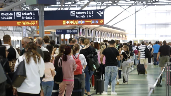 Passagiere stehen zu Anfang der Sommerferien 2022 in einer Schlange von mehreren hundert Metern f&uuml;r die Sicherheitskontrolle am Flughafen K&ouml;ln-Bonn an. Auch in diesem Jahr k&ouml;nnte die Abfertigung der Sicherheitskontrollen l&auml;nger dauern. - &copy; Thomas Banneyer