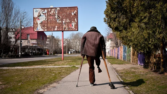 Artem (63), ein behinderter ukrainischer Mann, geht durch die Stra&szlig;en von Cherson, die noch von den Resten der Plakatw&auml;nde mit russischer Propaganda geschm&uuml;ckt sind. - &copy; www.krupar.com +420724014613