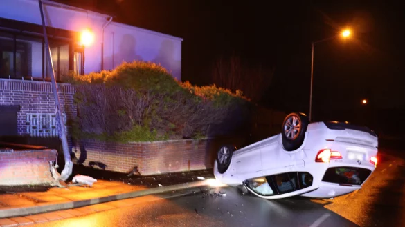 Der BMW landete nicht nur auf dem Dach, er besch&auml;digte auch eine Mauer und eine Stra&szlig;enlaterne. - &copy; Polizei