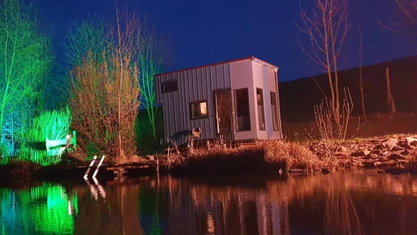 Nacht am Schwimmteich: Das blaue Kunst-Miniaturhaus von Museumsbauer Andreas Zelle ist aus recycelten Ausstellungsst&uuml;cken gebaut. Bislang war es in Stemwede zu finden. In diesem Sommer wird es voraussichtlich einen anderen interessanten Standort haben, auch dort ist es buchbar. - &copy; Andreas Zelle