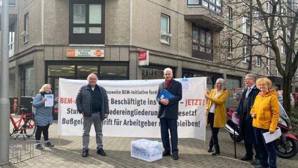 Protest: Das BEM-Bündnis hat in Berlin öffentlich Postkarten ans Arbeitsministerium übergeben und tut auch mit einem Banner seinen Unmut kund. - © BEM-Initiative