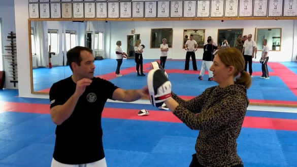 LZ-Mitarbeiterin Sandra Castrup hat die Deckung hochgefahren. Karate-Trainer Frank Herholt sucht vergeblich eine L&uuml;cke. Im Spiegel ist zu sehen, wie LZ-Boten im Trainingszentrum vom Verein Shotokan gerade erlernte Verteidigungstechniken anwenden. - &copy; Thomas Reineke