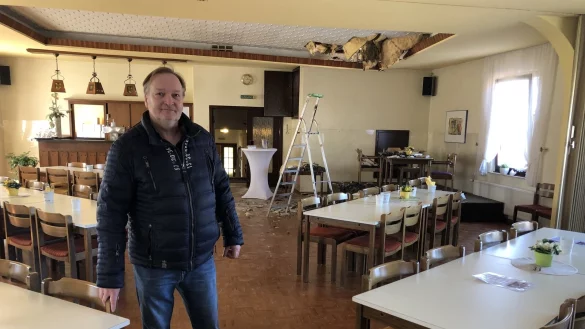 Stefan Stock steht im Veranstaltungssaal. Im Hintergrund ist das Loch in der Decke zum Dachstuhl zu sehen. Es k&ouml;nnte Monate dauern, bis der Raum wieder genutzt werden kann. - &copy; Sven Kienscherf