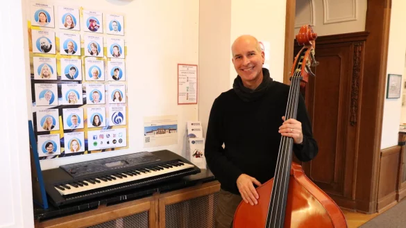 Stephan Otters steht mit Kontrabass und Keyboard vor dem Plakat seines Teams - ohne sie h&auml;tte er die 25 Jahre in Bad Salzuflen so nicht gestemmt, sagt er. - &copy; Alexandra Schaller