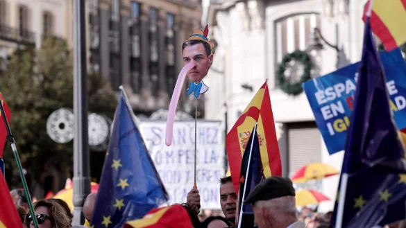 Ein Demonstrant h&auml;lt am 12. November bei einer Demonstration in Madrid ein Bild des spanischen Premierministers Pedro S&aacute;nchez mit langer "Pinocchio"-Nase hoch. Foto: Thomas Coex / AFP - &copy; AFP OR LICENSORS