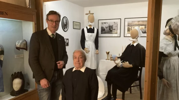 Museumsleiter Dr. Michael Zelle und Schwester Brigite freuen sich &uuml;ber die Erg&auml;nzung der Trachtenabteilung mit Trachten der Diakonissen. - &copy; Cordula Gr&ouml;ne