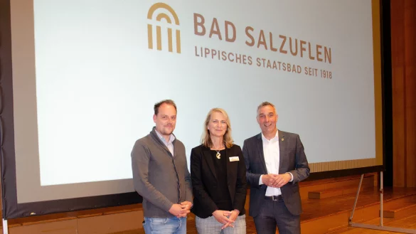 Alexander Bleifu&szlig; (von links) und Doris Halgmann-Bole vom Fachbereich Tourismus, Gesundheit und Marketing stehen mit B&uuml;rgermeister Dirk Tolkemitt vor dem neuen Logo der Stadt Bad Salzuflen. - &copy; Georg K&auml;lble