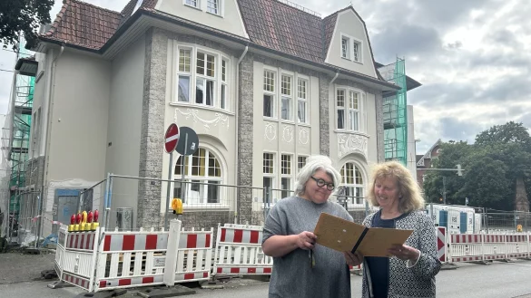 Marion B&uuml;hler (links) und Susanne Eerenstein werfen einen Blick in die Unterlagen. Im Hintergrund das Geb&auml;ude an der Seminarstra&szlig;e 3 - die denkmalgesch&uuml;tzte Fassade erstrahlt bereits in neuem Glanz. Zwei Millionen Euro investiert die Lippische Landeskirche insgesamt in den Umbau des Hauses. - &copy; Alexandra Schaller