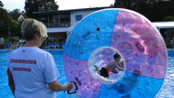 Gro&szlig;e Attraktion des Freibadfestes ist die "Aqua-Fun-Rolle". Sandra Reckstat organisiert den "Lauf &uuml;ber das Wasser" und sichert die Kinder im Spielger&auml;t. - &copy; Hajo G&auml;rtner