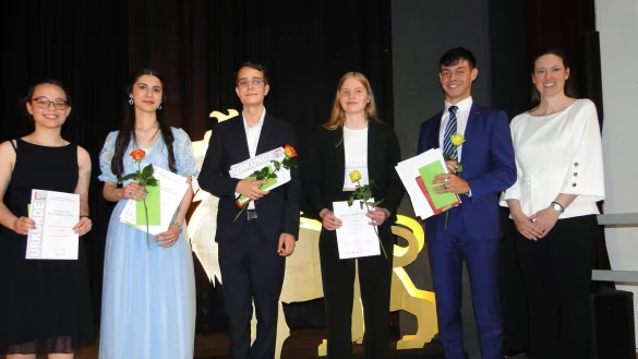 Schulleiterin Dr. Alexandra Nolte (rechts) hebt f&uuml;nf Sch&uuml;ler in der Abitur-Entlassfeier f&uuml;r Spitzenleistungen hervor. Stellvertreter f&uuml;r Dutzende von Absolventen, die sich in vielen F&auml;chern und Bereichen des schulischen Lebens besonders hervorgetan haben sind Lea Peter (von links), Lilaw Hussein, Luis Mateo Grobler, Lena Kuhlmann und Elia Noam Nestoris. - &copy; Hajo G&auml;rtner