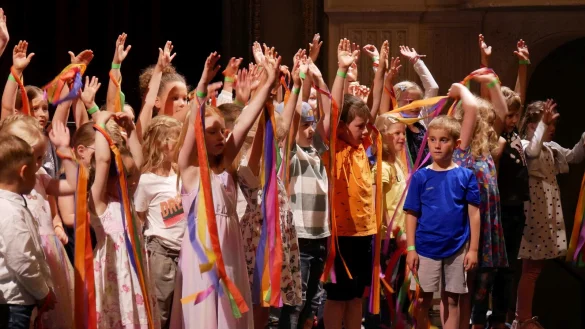 Wir sind Kinder einer Welt. Rund 80 Kinder begr&uuml;&szlig;en die G&auml;ste mit bunten B&auml;ndern auf der B&uuml;hne im Gro&szlig;en Saal. - &copy; Thomas Kr&uuml;gler