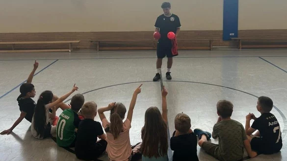 FSJler Ben Multhaupt erkl&auml;rt den Kindern der Ball-AG aus der OGS der Grundschule D&ouml;rentrup-Ost was sie machen sollen. - &copy; Fotorechte: Ben Multhaupt