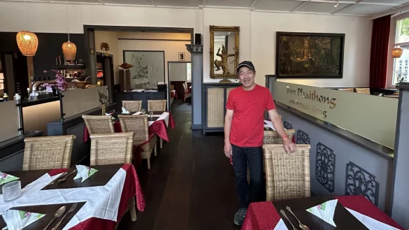 Vieng Vilay Davong steht im Gastraum des "Ban Phaithong im Neuen Krug". - © Alexandra Schaller