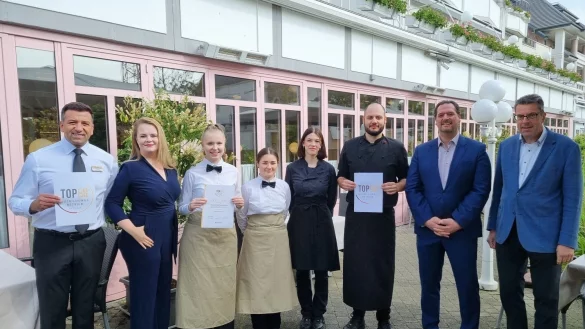 Freuen sich &uuml;ber die erneute Auszeichnung als Top-Ausbildungsbetrieb durch Verbandsgesch&auml;ftsf&uuml;hrer Kai Buhrke (rechts): Inhaberin Swetlana Lenger (2 von links) und Inhaber Matthias Lenger (2. von rechts) mit Restaurantleiter Ali Kaplan (links) und vier Auszubildende des Kurparkhotels. - &copy; Dehoga