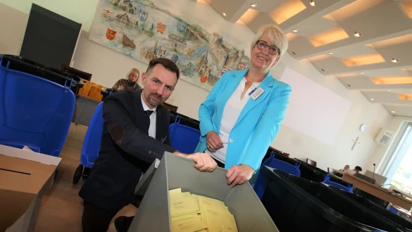 Im gro&szlig;en Sitzungssaal des Kreishauses Paderborn zeigen Christopher Sch&uuml;ngel, Leiter des Kreistagsb&uuml;ros, und Annette M&uuml;hlenhoff, Vorsitzende des Wahlvorstands, eine Urne mit Unterlagen zur Weiterverarbeitung. Hierbei handelt es sich um Stimmen aus Bad W&uuml;nnenberg. - &copy; Rajkumar Mukherjee