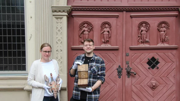 Dr. Sonja Girod (VHS Lemgo, links) mit einer aus Indonesien stammenden Hausverzierung und Simon Bucher, (Volont&auml;r Hexenb&uuml;rgermeisterhaus) mit einem "Orakel-Buch". - &copy; Kyrill von Matuschka