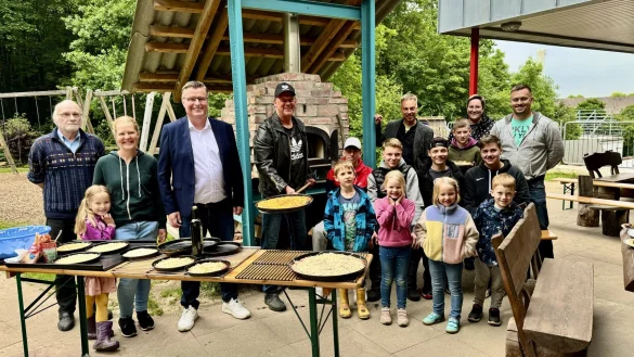 Die erste Pizza wird serviert: Ideegeber, Ofenbauer, Eltern und Sch&uuml;ler und Kita-Kinder lassen es sich schmecken. - &copy; Lippe Bildung