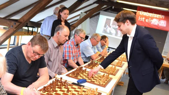 Matthias Bl&uuml;baum geht von Schachbrett zu Schachbrett und besiegt innerhalb von drei Stunden 21 seiner 22 Gegner. Einem gelingt am Ende ein Remis. - &copy; Karin Prignitz