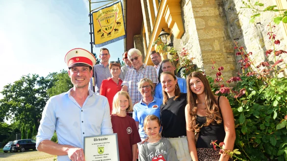 Christoph Krietenstein erhält zur Ernennung als Ehrenmitglied eine Urkunde und eine Offiziersmütze, mit ihm freuen sich seine Familie und ein Teil des Vorstandes der Schützengilde Lage. - © Nicole Ellerbrake