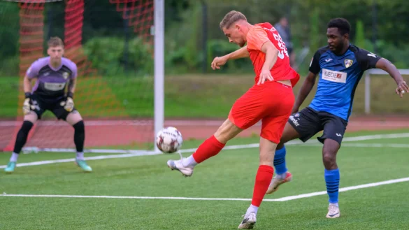 Der Postler Julian Jobstmeier (rot) setzt sich erfolgreich in Szene durch und schießt auf das Herforder Tor. Der Ball geht an die Latte. Der Herforder Dieudonne Chalier Ndongengaga Menie (blau) kann nicht mehr eingreifen. - © Egon Penner