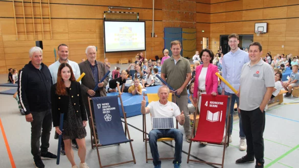 Friedhelm Susok (Mitte, sitzend) stimmt die Kinder und die Erwachsenen auf den Energieunterricht ein. Passend dazu hat er eine Solarzelle dabei. Mit dabei (von links) Thomas Grundmann (Schulleiter der Grundschule Knetterheide), Gina Wattenberg (Stadtwerke Lemgo), Tobias Pri&szlig; (Kreis Lippe), J&uuml;rgen Georgi (Umweltstiftung Lippe), Stefan Sch&ouml;bel (Blomberger Versorgungsbetriebe), Eva Ellminger (Stadtwerke Detmold), Moritz Sibma (Stadtwerke Bad Salzuflen) und Michael Makosch (Stadtwerke Oerlinghausen). - &copy; Kreis Lippe