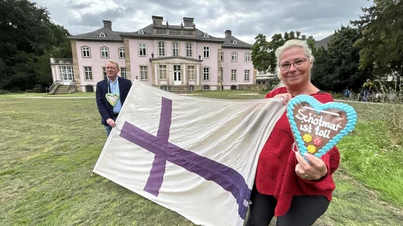 Nicole Stock und Andr&eacute; Schr&ouml;der vom Sch&ouml;tmaraner B&uuml;rgerverein halten die Kiliansfahne und freuen sich auf das erste Kiliansfest, bei dem auch der Schlosspark in Sch&ouml;tmar mit eingebunden wird. - &copy; Alexandra Schaller