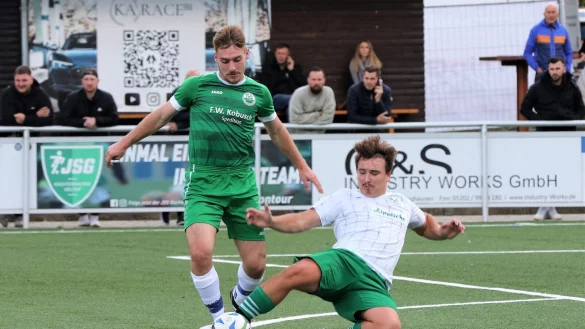 Keinen Ball gibt Belles Moritz Hartmann verloren und grätscht hier im Duell mit Kachtenhausens Tobias Prib. - © Oliver König