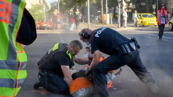 Berlin, 18. September: Polizisten s&auml;gen ein St&uuml;ck Stra&szlig;e mit einer Kreiss&auml;ge heraus. Eine Aktivistin hatte sich mit einem Sand-Kleber-Gemisch an die Stra&szlig;e geklebt. - &copy; picture alliance / PIC ONE