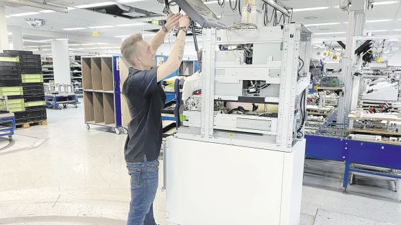 Von der Blechbearbeitung bis zum fertigen Ger&auml;t gibt es in Paderborn, dem gr&ouml;&szlig;ten Werk des Konzerns, eine hohe Fertigungstiefe. Das Foto zeigt die &bdquo;Hochzeit&ldquo; von Tresor und Geldautomat. - &copy; krause