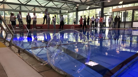 Die geladenen G&auml;ste schauen sich das rundsanierte Hallenbad an. Im Vordergrund das Schwimmerbecken mit dem Hubboden. - &copy; Thomas Reineke