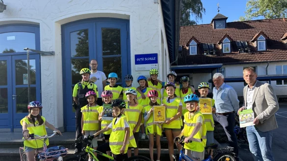 Die vierte Klasse der Werretalschule startet die Fahrradprüfung mit der Polizeioberkommissarin Tanja Menze (links), Karsten Seefeldt von der Verkehrswacht und Jens Klusmeier von der Lippischen Landesbrandversicherung (rechts). - © Karlotta Hensch