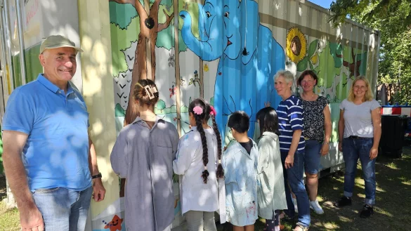 Wilhelm Wortberg hat gemeinsam mit Petra Niederdorf (Dritte von rechts) das Kunstprojekt vorbereitet. Der blaue Elefant ist das G&uuml;tezeichen der Einrichtung. Monika Frodermann und Anna Lena Beermann (rechts) freuen sich, dass sie endlich einen so sch&ouml;nen Platz haben, um Spielzeug und Kinderfahrzeuge zu verstauen. - &copy; Astrid Sewing