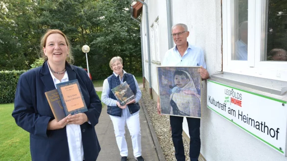 Gleichstellungsbeauftragte Grita Behrens (links) sowie Inge und Bernd Hoffmann vom Vorstand des Heimatvereins Leopoldsh&ouml;he zeigen B&uuml;cher der beiden Frauen und ein Selbstbildnis mit Pfeife von Ilse H&auml;fner-Mode aus dem Jahr 1949. - &copy; Karin Prignitz