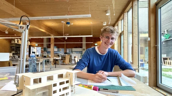 Sichtbar glücklich: Luis sitzt in einem Saal der Alanus Kunsthochschule vor einem seiner ersten selbstgebauten Modelle. - © privat