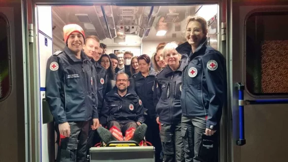 Ehrenamtliche des DRK nehmen Rotkreuzleiter Matthias Schalk in einem Rettungswagen in ihre Mitte. - &copy; DRK Bad Salzuflen