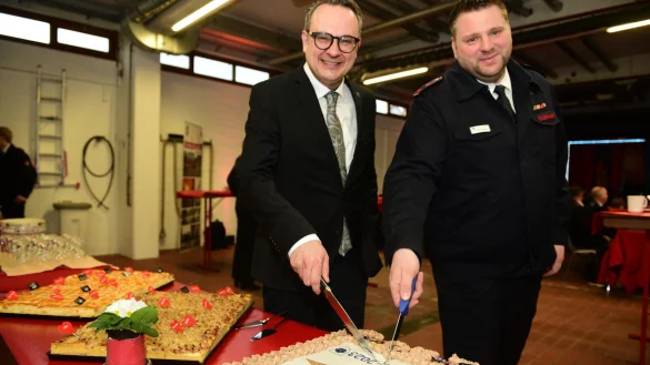 B&uuml;rgermeister Markus Baier und Stadtjugendfeuerwehrwart Christian Heidemann schneiden den Jubil&auml;umskuchen an - &copy; Nicole Ellerbrake
