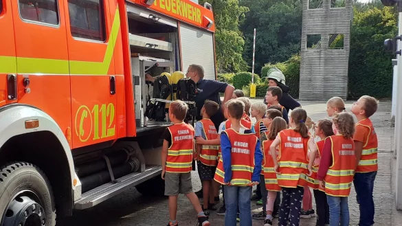 Die kleinen Feuerwehrleute betrachten an der Wache an der Oerlinghauser Stra&szlig;e die pralle Ausr&uuml;stung eines Feuerwehrwagens. - &copy; Freiwillige Feuerwehr Bad Salzuflen