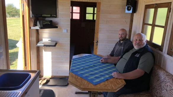 Friedrich-Wilhelm M&uuml;gge und Sohn Thorsten sitzen im Wohnzimmer des gr&ouml;&szlig;ten der drei Bauwagen. - &copy; Sven Kienscherf