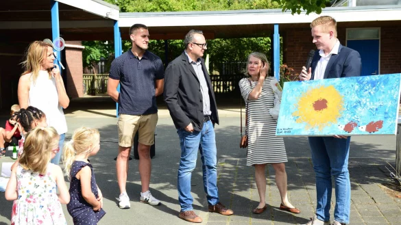 Die Kindergartenkinder überreichen Ortsvorsteher Janik Wiemann zur Einweihung ein selbstgemaltes Bild, das umgehend in dem Multifunktionsraum aufgehägt wurde. - © Nicole Ellerbrake