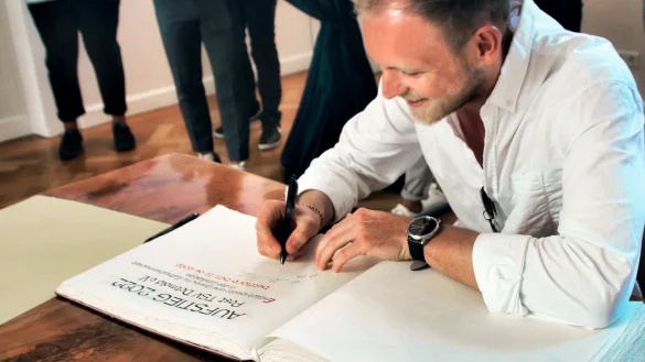 Alex Felker und die Fu&szlig;baller des Post TSV-Detmold unterschreiben im Goldenen Buch. - &copy; Stadt Detmold