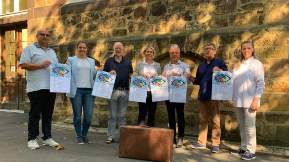 B&uuml;lent Yilmaz, (von links) Anika Humme, Jobst Fl&ouml;rkemeier, D&eacute;sir&eacute;e Solle, Andreas Gronemeier, Michael Meier und Dorothea Senz vom Organisationsteam der interkulturellen Woche stehen vor einem Koffer, der symbolisch f&uuml;r die wenigen Sachen steht, mit denen die Menschen im Rahmen des Anwerbeabkommens nach Deutschland, in dem Glauben, irgendwann zur&uuml;ckzukehren, gekommen sind - &copy; Stadt Bad Salzuflen