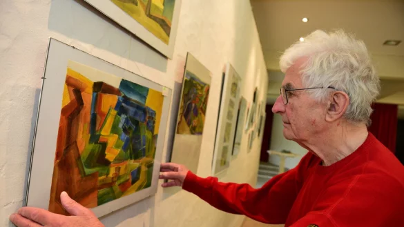Bilder von Gerhard Wellmer h&auml;ngen in dem gro&szlig;en Saal des Gemeindehauses, die der K&uuml;nstler stolz pr&auml;sentiert. - &copy; Nicole Ellerbrake