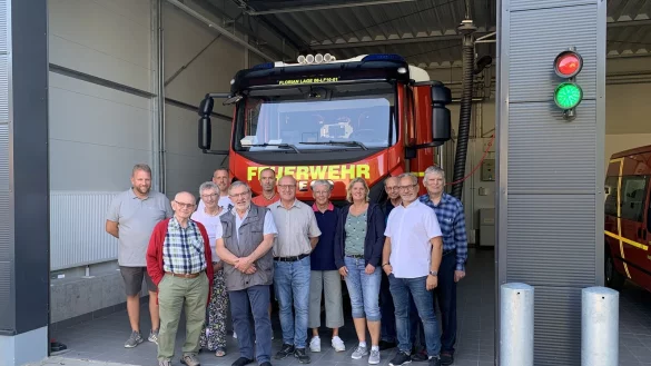 Vor der neuen Fahrzeughalle und dem Einsatzfahrzeug stehen die Teilnehmer der Veranstaltung, links L&ouml;schgruppenleiter Andreas Bicker, Zweiter von rechts Andreas Fritz, Vorsitzender des SPD-Ortsvereins Hagen/Hardissen. - &copy; SPD