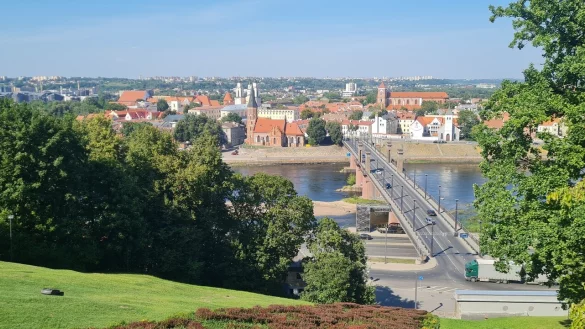 Blick auf Kaunas. W&auml;hrend der &ouml;ffentliche Hang von einem M&auml;hroboter gepflegt wird, zeigt sich die Innenstadt von ihrer besten Seite. Die Trabantenst&auml;dte im Hintergrund freilich bieten ein deutlich trostloseres Bild mit verfallenen Holzh&auml;usern und Plattenbauten aus russischer Zeit. - &copy; Marianne Schwarzer
