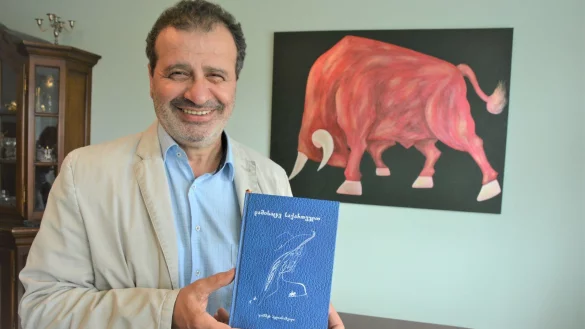 Jimsher Bedianashvili mit seinem neuesten Gedichtband. Dazu inspiriert worden ist er vom Bild seiner Tochter Natia, auf dem Stier Ciqara aus einem der bekanntesten georgischen M&auml;rchen zu sehen ist. - &copy; Karin Prignitz