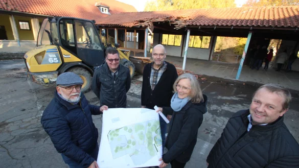 W&auml;hrend im Hintergrund der Bagger schon Teile des Dachs in Angriff genommen hat, zeigen SPD-Fraktionschef Manfred Rehse (von links), CDU-Ratsherr Olaf Copony, Fachbereichsleiter Olaf Kapelle, Bauamts-Architektin Ute Seidemann und B&uuml;rgermeister Mario Hecker den Plan f&uuml;r die k&uuml;nftige Gestaltung des Grundschul-Gel&auml;ndes in Hohenhausen. - &copy; Jens Rademacher