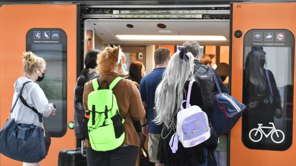 Bahnfahrer dr&auml;ngen sich am Sonntag am Eingang eines Regionalzuges am Deuter Bahnhof. Durch das 9-Euro-Ticket verzeichnet die Deutsche Bahn mehr ausgelastete Z&uuml;ge an Pfingsten. - &copy; Roberto Pfeil/dpa