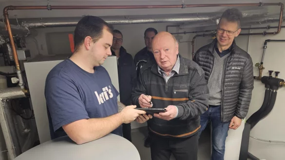 Marvin Prothmann (links) l&auml;sst den Pr&uuml;fbericht von Hans Le&szlig;mann unterschreiben. Dieser kann jetzt sicher sein, dass seine Heizungsanlage das H-Gas auch sicher verarbeiten kann. Im Hintergrund stehen (von links) Frank J&auml;dicke und Alexander Meier zu Evenhausen. Michael Wippermann (rechts) schaut Le&szlig;mann &uuml;ber die Schulter. - &copy; Astrid Sewing